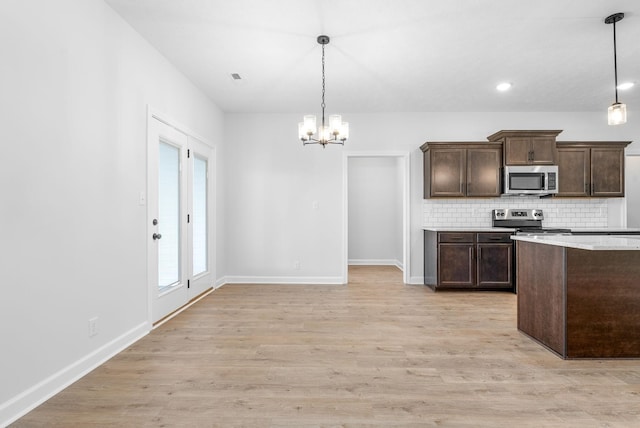 kitchen with stainless steel appliances, hanging light fixtures, backsplash, and dark brown cabinetry