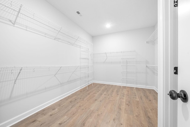 walk in closet with light hardwood / wood-style flooring