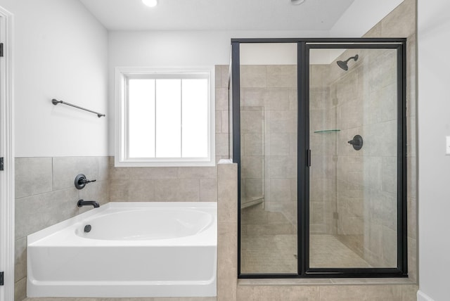 bathroom featuring shower with separate bathtub