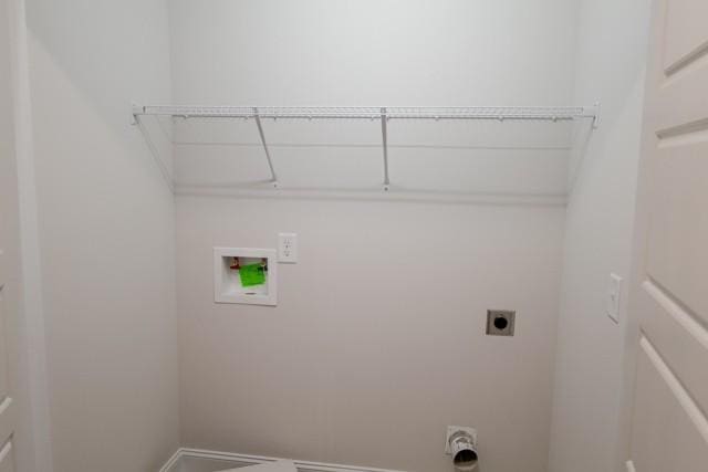 clothes washing area featuring laundry area, hookup for a washing machine, electric dryer hookup, and baseboards