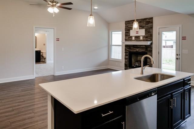 kitchen with dishwasher, lofted ceiling, open floor plan, light countertops, and a sink