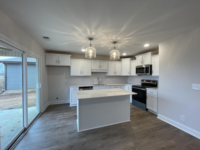 kitchen with stainless steel appliances, a kitchen island, a sink, visible vents, and a healthy amount of sunlight