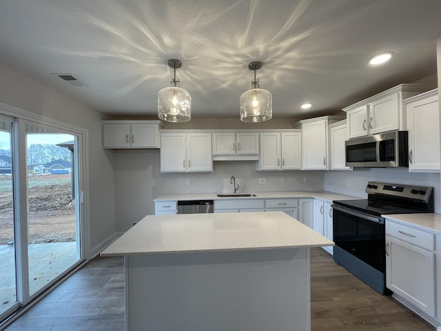 kitchen with appliances with stainless steel finishes, visible vents, a sink, and white cabinetry