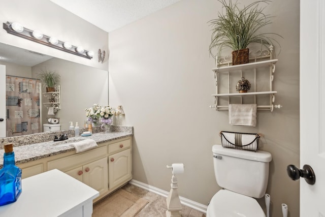 bathroom featuring toilet, a textured ceiling, tile patterned floors, and vanity