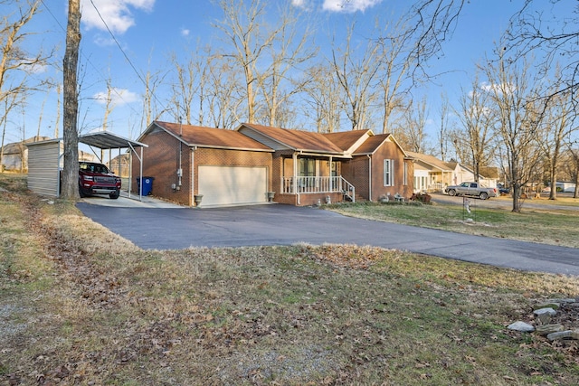 view of front of property featuring covered porch, a front lawn, a garage, and a carport