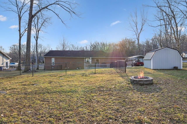 view of yard with an outdoor fire pit and a storage shed