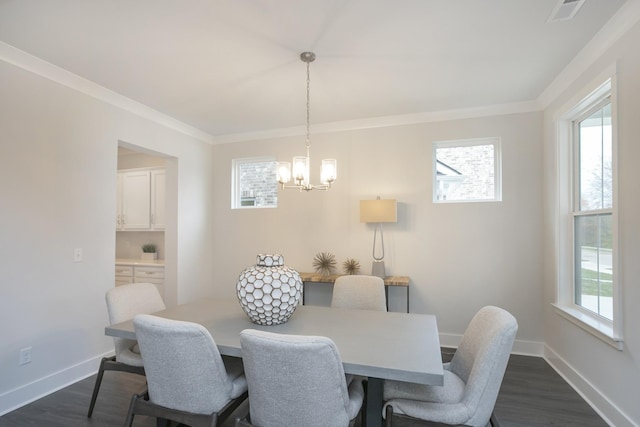 dining space featuring plenty of natural light, an inviting chandelier, crown molding, and dark hardwood / wood-style floors