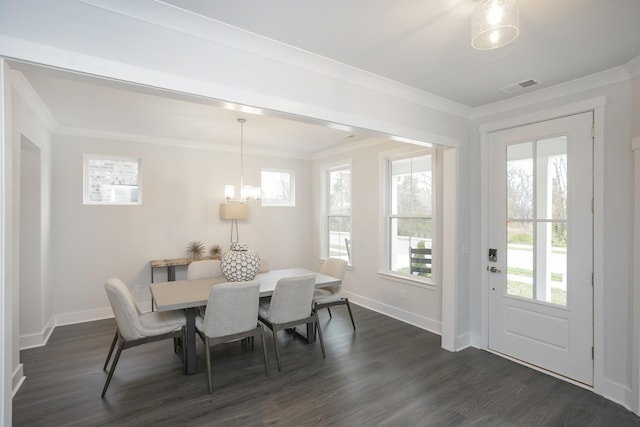 dining room with dark wood-type flooring, crown molding, and an inviting chandelier