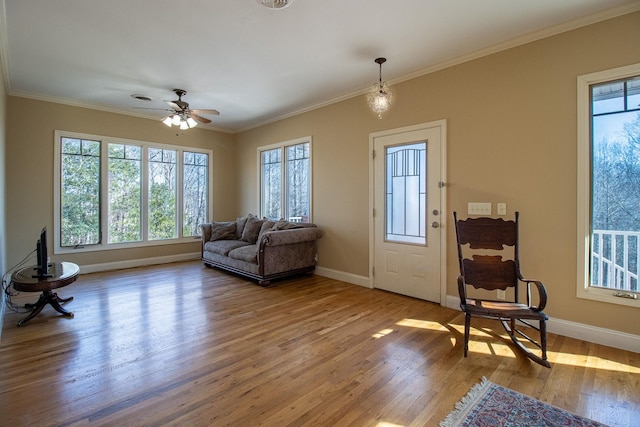 living area featuring ceiling fan, hardwood / wood-style floors, and crown molding