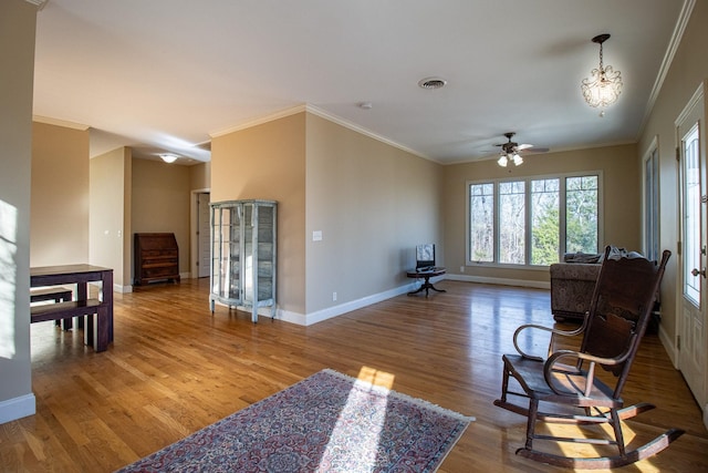 sitting room featuring ceiling fan with notable chandelier, crown molding, and hardwood / wood-style floors