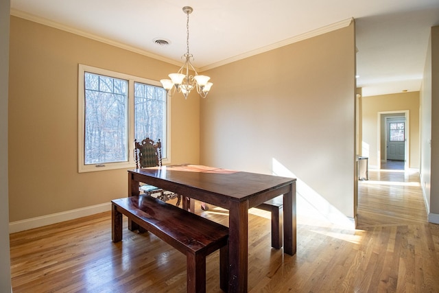 dining room with an inviting chandelier, crown molding, a wealth of natural light, and hardwood / wood-style floors