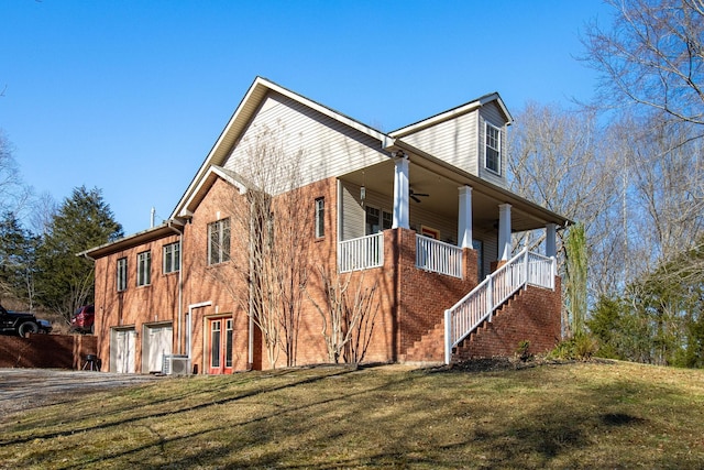 view of side of home with a lawn, covered porch, and a garage