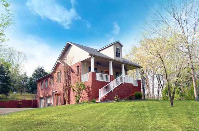 view of front of house with stairway, an attached garage, a ceiling fan, and a front lawn