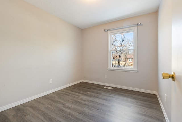 unfurnished room with dark hardwood / wood-style flooring