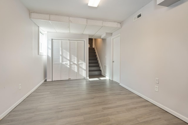 empty room featuring a paneled ceiling and light wood-type flooring