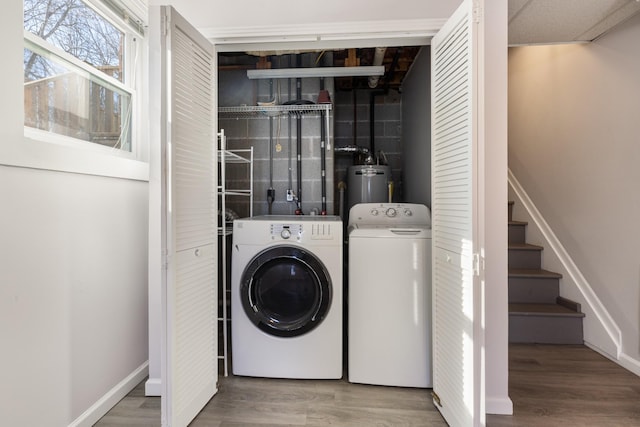 laundry room featuring gas water heater, hardwood / wood-style floors, and independent washer and dryer