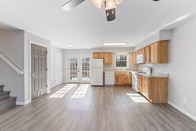 kitchen featuring white appliances, ceiling fan, french doors, sink, and light hardwood / wood-style flooring