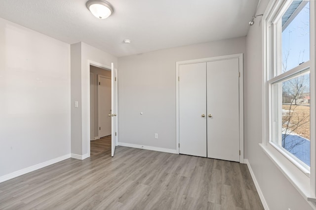 unfurnished bedroom featuring light hardwood / wood-style floors and a closet