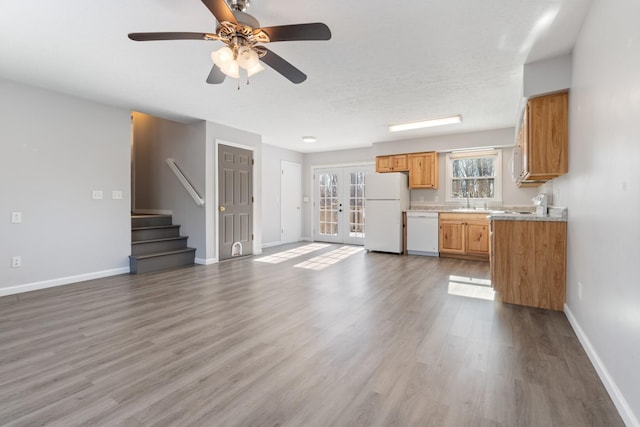 unfurnished living room with sink, ceiling fan, french doors, and hardwood / wood-style floors