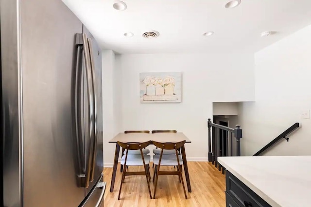 kitchen featuring stainless steel refrigerator and light hardwood / wood-style flooring