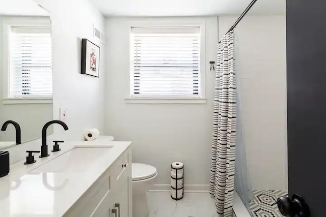 bathroom featuring toilet, vanity, and curtained shower