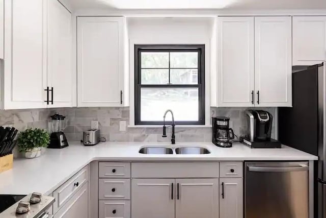 kitchen featuring sink, white cabinets, decorative backsplash, and dishwasher