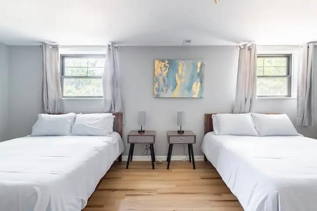 bedroom featuring light hardwood / wood-style floors and multiple windows