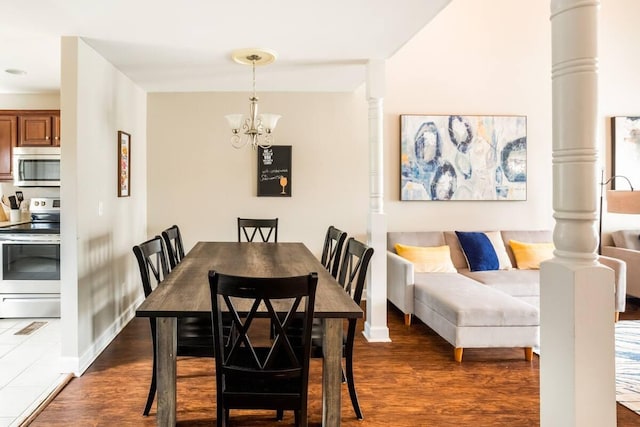 dining area featuring dark hardwood / wood-style flooring and an inviting chandelier