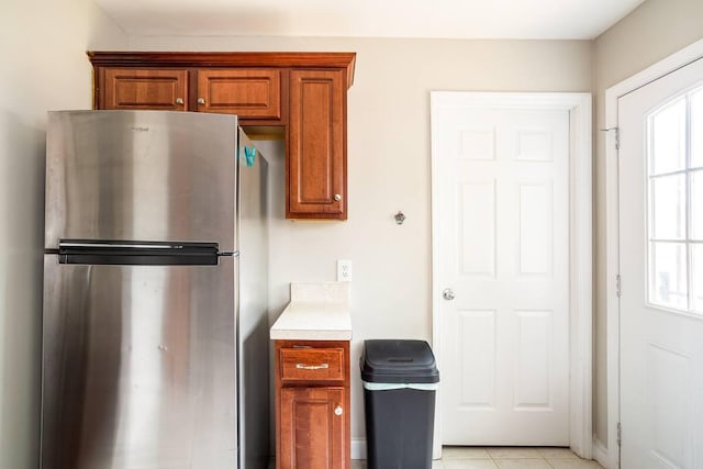 kitchen featuring stainless steel refrigerator and light tile patterned floors