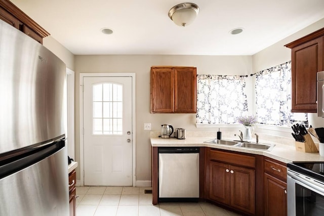 kitchen with stainless steel appliances, sink, and light tile patterned floors