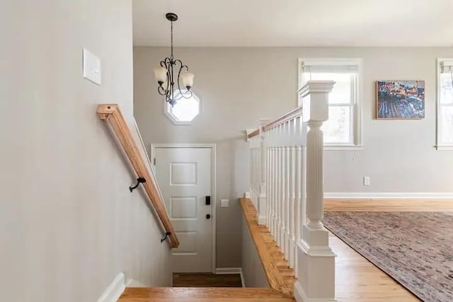 stairs featuring a chandelier and hardwood / wood-style flooring