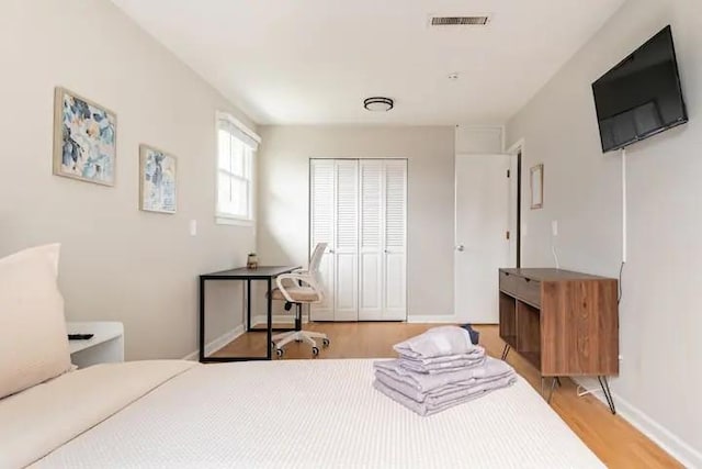 bedroom with a closet and light hardwood / wood-style floors