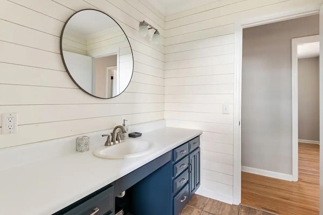 bathroom with wooden walls, vanity, and hardwood / wood-style floors