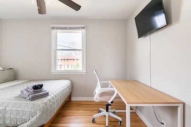 bedroom with hardwood / wood-style flooring, ceiling fan, and multiple windows