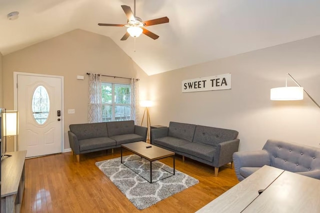 living room with ceiling fan, vaulted ceiling, and hardwood / wood-style floors