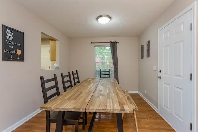 dining space with wood-type flooring