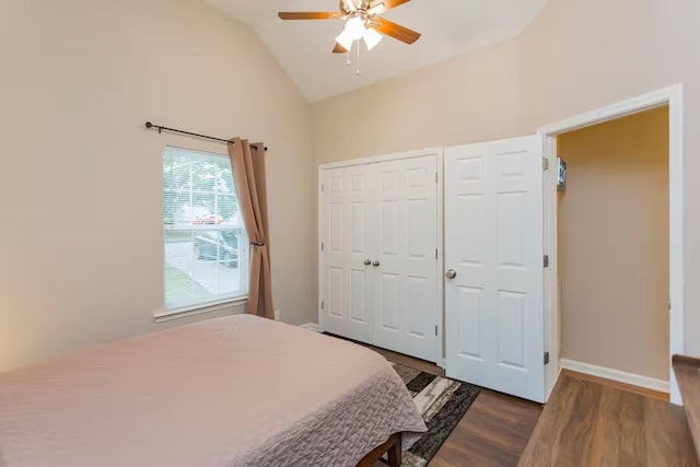 bedroom with ceiling fan, vaulted ceiling, and dark wood-type flooring