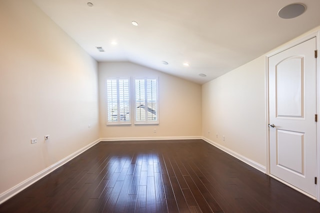 empty room featuring dark hardwood / wood-style flooring and lofted ceiling