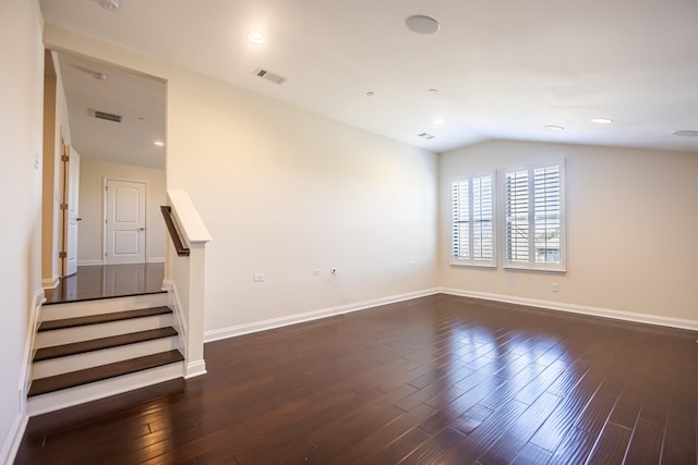 spare room with vaulted ceiling and dark hardwood / wood-style floors