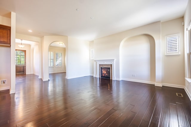 unfurnished living room featuring dark hardwood / wood-style flooring and a fireplace