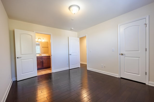 unfurnished bedroom featuring dark hardwood / wood-style floors and connected bathroom