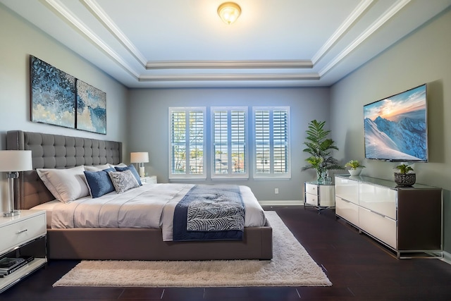 bedroom with dark hardwood / wood-style flooring, a tray ceiling, and crown molding