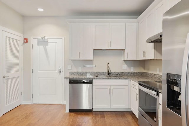 kitchen featuring light hardwood / wood-style floors, stainless steel appliances, light stone counters, sink, and white cabinetry