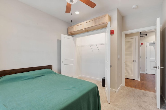 bedroom featuring ceiling fan, light colored carpet, and a closet