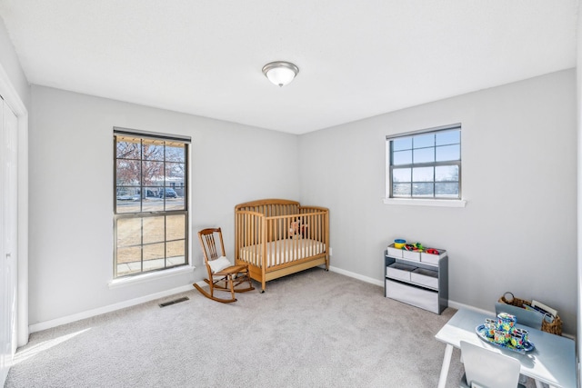 bedroom featuring a crib and carpet