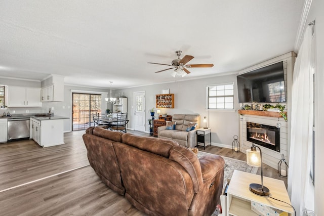 living room featuring ornamental molding, hardwood / wood-style floors, a textured ceiling, and ceiling fan with notable chandelier