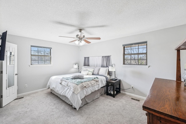 carpeted bedroom featuring a textured ceiling and ceiling fan