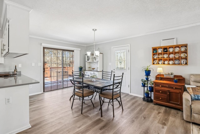 dining room featuring hardwood / wood-style floors, an inviting chandelier, ornamental molding, and a healthy amount of sunlight