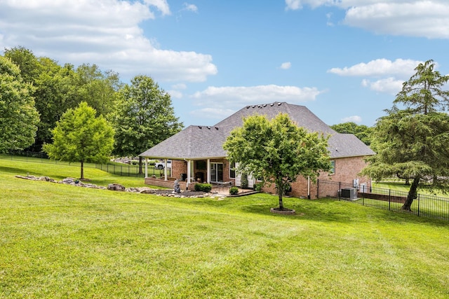 back of house featuring a yard, central AC, and a patio