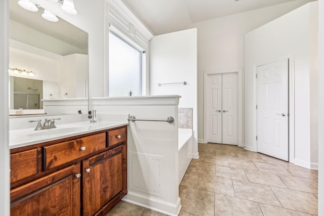 bathroom featuring a bath, tile patterned floors, and vanity